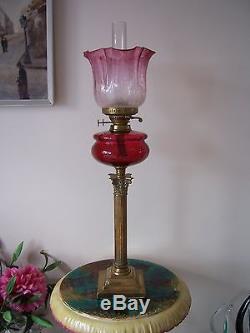 A Tall Victorian Brass Column Cranberry Glass Oil Lamp And Shade