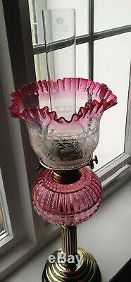A Victorian brass and cranberry glass oil lamp