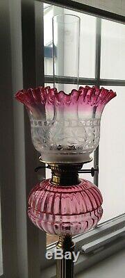 A Victorian brass and cranberry glass oil lamp