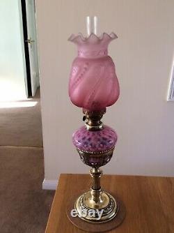 An Antique Cranberry Drop In Font Oil Lamp and Cranberry Shade